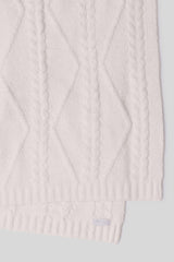 Close-up of a cream cable knit scarf on a white background