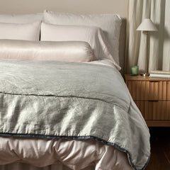 Paloma Bed End Blanket from Bella Notte Linens in the color Cloud displayed on a bed with shams and a duvet also from Bella Notte Linens. 