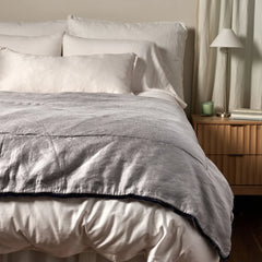 Paloma Bed End Blanket from Bella Notte Linens in the color French Lavender displayed on a bed with shams and a duvet also from Bella Notte Linens. 