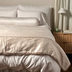 Paloma Bed End Blanket from Bella Notte Linens in the color Pearl displayed on a bed with shams and a duvet also from Bella Notte Linens. 