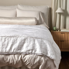 Paloma Bed End Blanket from Bella Notte Linens in the color White displayed on a bed with shams and a duvet also from Bella Notte Linens. 