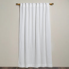 Winter White Linen curtain from Bella Notte Linens hanging on a wooden rod against a beige wall.