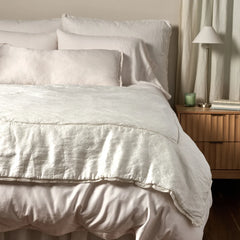 Paloma Bed End Blanket from Bella Notte Linens in the color Winter White displayed on a bed with shams and a duvet also from Bella Notte Linens. 